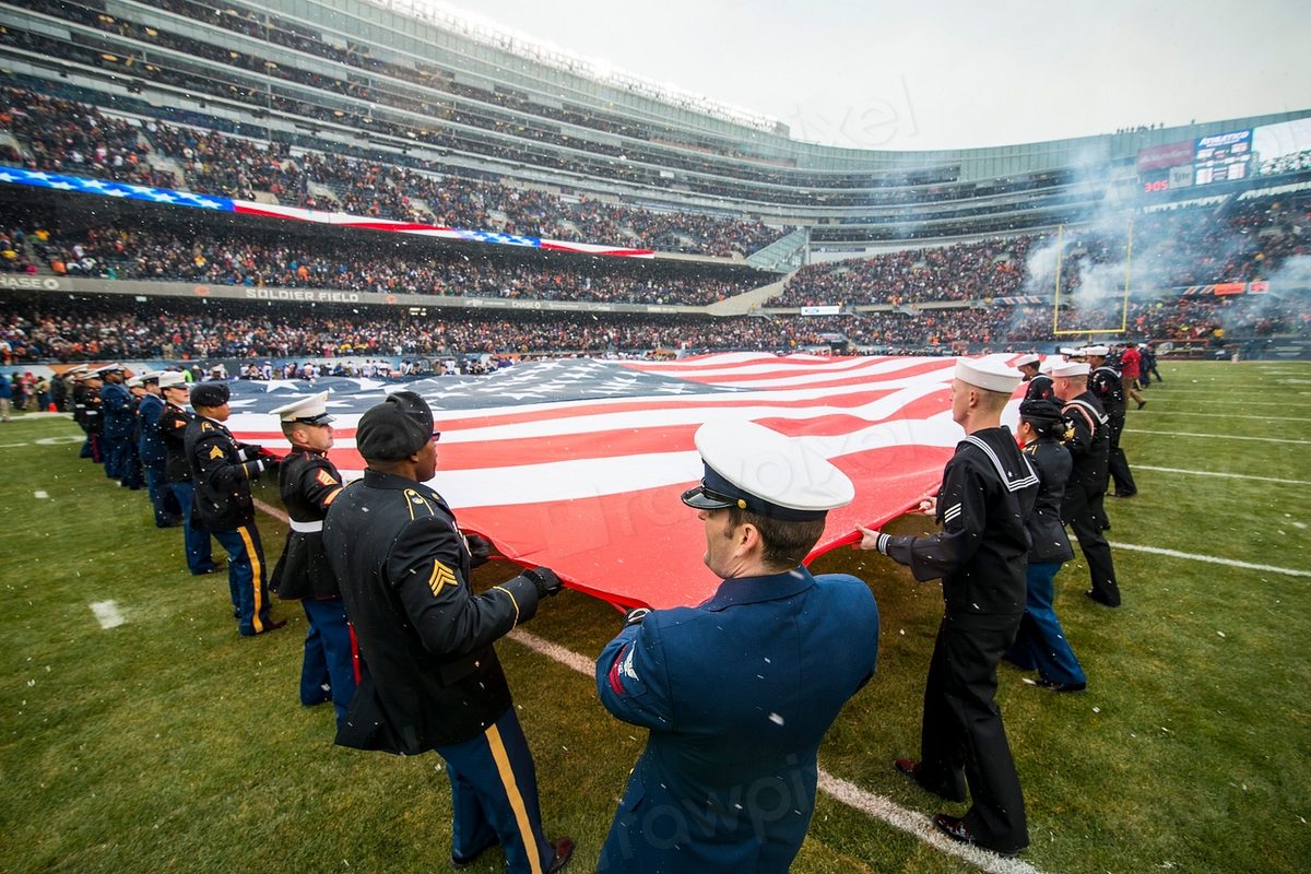 A military honor guard unfurling the American flag.